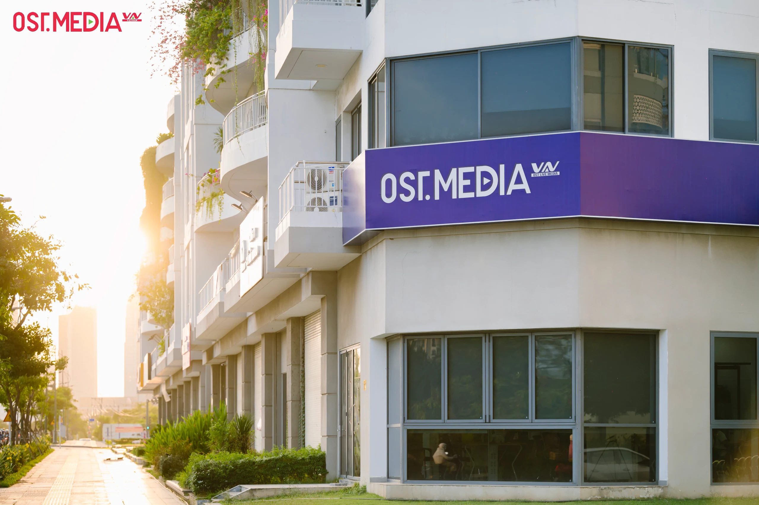 Mặt tiền văn phòng với biển hiệu OST.MEDIA trong ánh nắng chiều