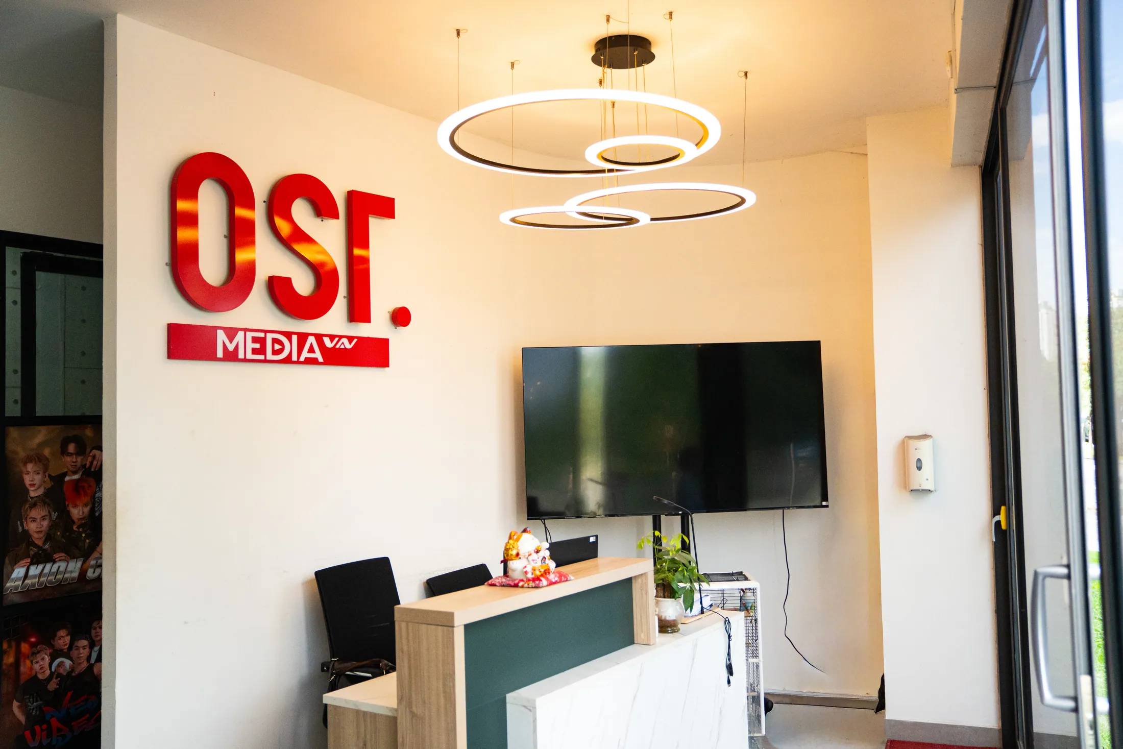 Khu vực lễ tân với logo OSTMEDIA màu đỏ.